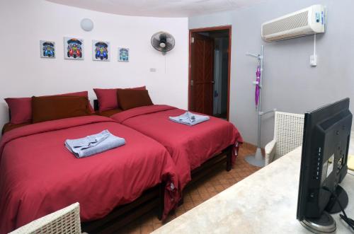 麦岛麦岛布里茅屋自然度假酒店的一间卧室配有红色的床和电视