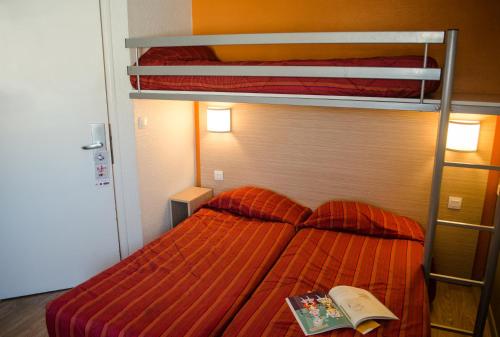 加来HECO Calais Centre-Gare的一间卧室配有一张双层床,上面有一本书