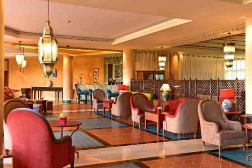 辛特拉辛特拉佩斯塔纳高尔夫SPA度假酒店的大堂设有桌椅和酒吧。