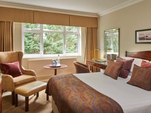 阿斯科特麦克唐纳德贝里斯特德酒店&SPA的配有一张床和一把椅子的酒店客房