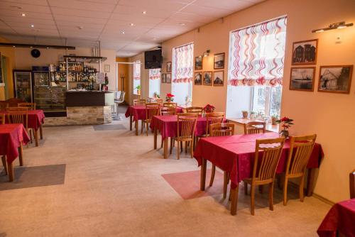 穆斯特韦埃Ankur Hotell的餐厅配有桌椅和红色桌布