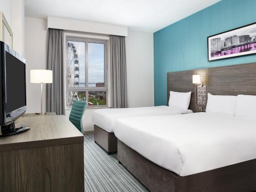 利物浦Leonardo Hotel Liverpool的酒店客房设有两张床和一台平面电视。
