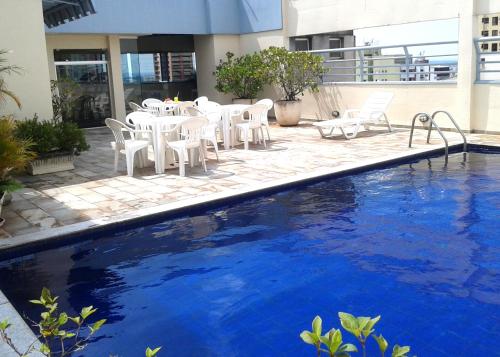 隆德里纳克里伦宫大酒店的一个带白色椅子和桌子的游泳池以及一个游泳池