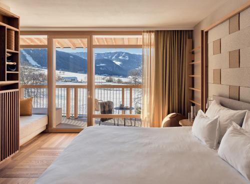 布鲁尼科Falkensteiner Hotel Kronplatz - The Leading Hotels of the World的一间卧室设有一张床和一个大窗户