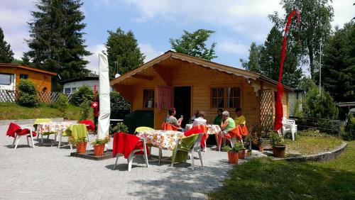 Schönengrund皮尔格-胡特里度假屋的一群坐在房子前面桌子的人