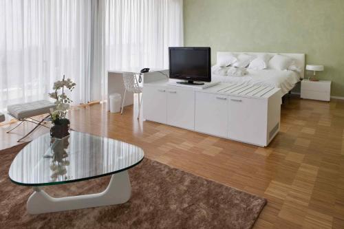 Entrena博德加芬卡洛斯阿迪诺斯酒店的客厅设有1张床和1张桌子及电视