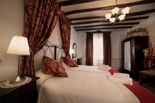 Urrea de GaenCasa Rural La Casona的一间卧室配有一张带红色窗帘的大床