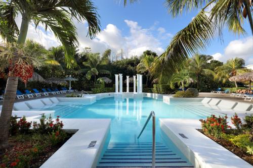 卢西牙买加帕拉丢姆度假村及Spa全包大酒店的一座棕榈树和蓝色海水游泳池