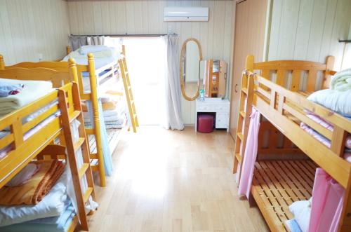 五岛五岛雨通宿酒店的宿舍间设有几张双层床和走廊。