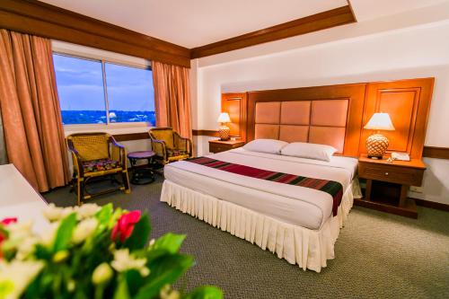 呵叻拉亚大酒店的酒店客房带一张床、一张桌子和椅子