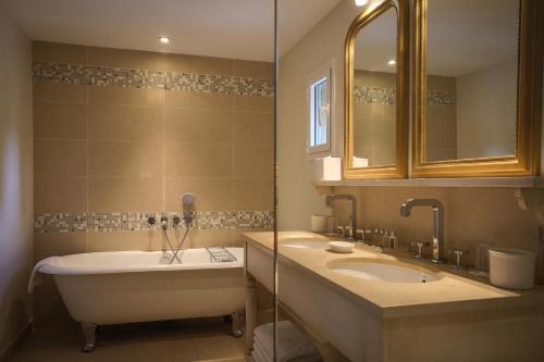 拉克鲁瓦瓦尔梅瓦尔玛城堡酒店的浴室设有2个水槽、浴缸和镜子
