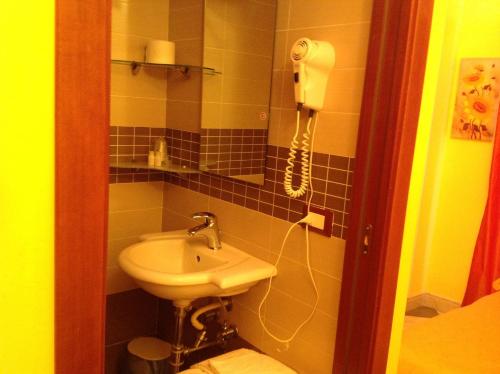福贾Bed & Breakfast Federico II的一间带水槽的浴室和墙上的一部电话
