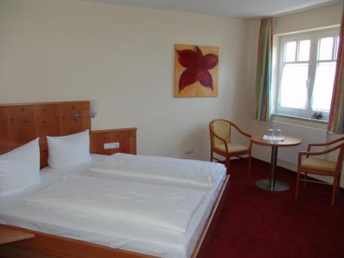 布尔高弗特克内赫特潘森酒店的一间卧室配有一张床和一张桌子及椅子