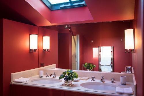 莱奥尼昂Château Le Pape B&B的一间带两个盥洗盆和大镜子的浴室