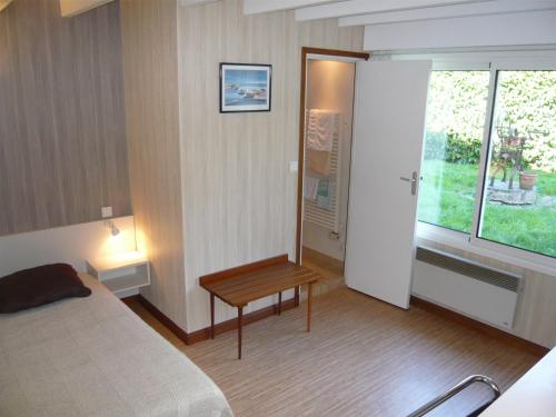 圣锡尔万当茹Guest House La Fauvelaie的一间卧室配有一张床、一张桌子和一个窗户。