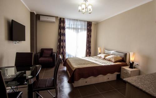 巴统My Batumi Apartments的卧室配有床、椅子和窗户。