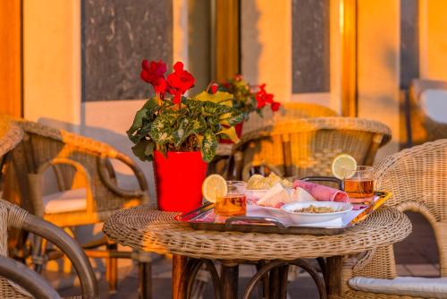 内图诺阿斯图拉宫酒店的一张桌子,上面放着一盘食物和一瓶红玫瑰花