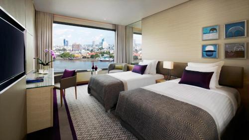 曼谷曼谷安凡尼+河畔酒店的酒店客房设有两张床和大窗户。