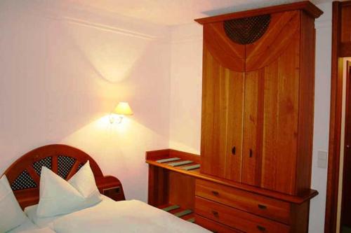 RodewischHotel Rodewisch的一间卧室配有一张床和一个木制橱柜