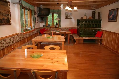 Stahovica伯德尼克宾馆的餐厅设有木桌、椅子和沙发。