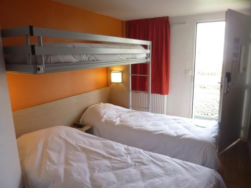 斯特拉斯堡贡比涅 - 亚克斯普瑞米尔经典酒店的酒店客房设有两张床和窗户。