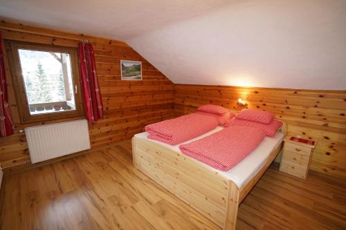 施图拜河谷新施蒂夫特Haus Ruetzbach的木制客房内的一间卧室,配有一张床