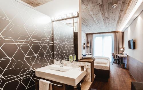 库夫施泰因库夫施泰因阿特酒店的一间带水槽的浴室和一张位于客房内的床