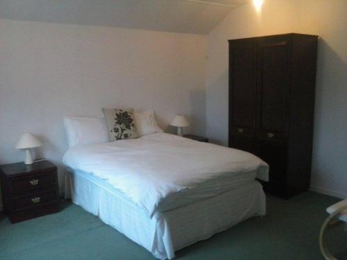 LochgairLochgair Hotel的卧室配有白色的床和黑色橱柜。
