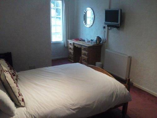 LochgairLochgair Hotel的一间卧室配有一张床、一张书桌和一台电视