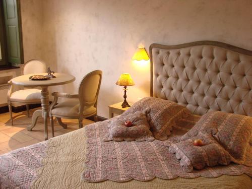 Ladoix Serrigny拉都瓦庄园酒店的卧室配有一张床和一张桌子及椅子