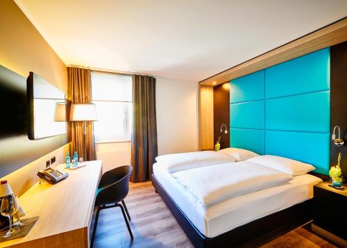 Rietheim-Weilheim旅程欢愉酒店的酒店客房设有一张大床和一张书桌。