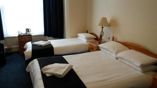普雷斯顿阿什伍德酒店的酒店客房设有三张床和窗户。