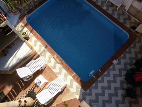 亚松森ApartHotel Maison Suisse的享有带2把草坪椅的游泳池的顶部景致