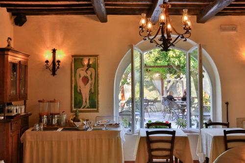 费拉约港圣斯特凡诺酒店 的一间带桌子和拱形窗户的用餐室