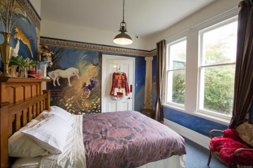 奥玛鲁玛丽布鲁克住宿加早餐旅馆的卧室配有一张床,墙上挂有绘画作品
