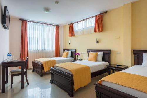阿约拉港Hotel Flamingo的酒店客房设有两张床和一张桌子。