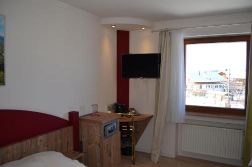 哈尔布莱希阿而浦沙勒施湾斯特恩酒店的一间卧室设有一张床、一台电视和一个窗口。