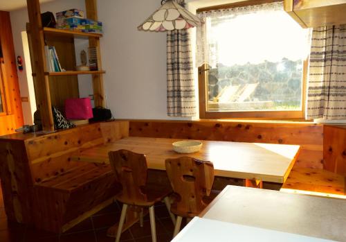 卡瓦莱塞Appartamento Bellavista的一间带木桌和窗户的用餐室