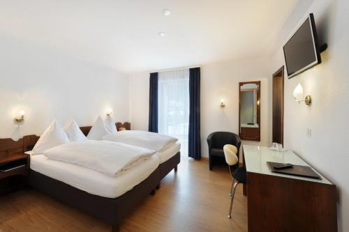 达沃斯迪仕玛酒店的配有一张床和一张书桌的酒店客房
