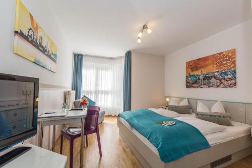 慕尼黑Hotel AMENITY的一间卧室配有一张床、一张书桌和一台电视。