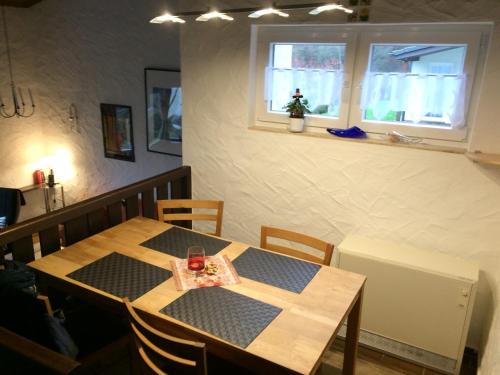 比尔斯多夫Ferienhaus Stausee Bitburg的一间带桌椅和窗户的用餐室