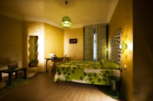 罗马多莫斯戴安娜酒店的一间卧室配有一张带绿色棉被的床