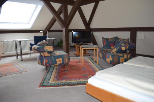 劳芬堡Alte Post - Hotel Am Rhein-Ufer Laufenburg的配有床、椅子和电视的房间