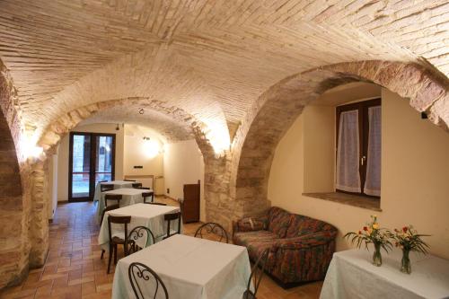 阿西西阿尔贝格拉罗卡酒店的客厅设有拱门和桌椅