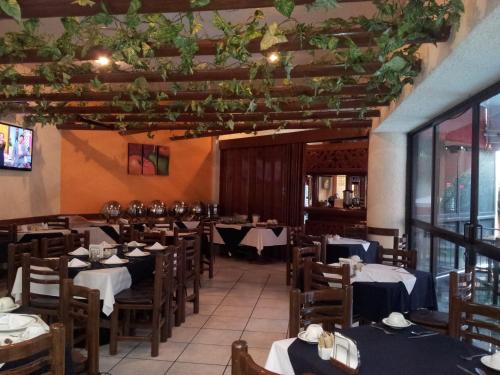 库埃纳瓦卡Hotel Real del Sol的餐厅内带桌椅的用餐室