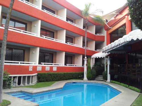 库埃纳瓦卡Hotel Real del Sol的大楼前设有游泳池的酒店
