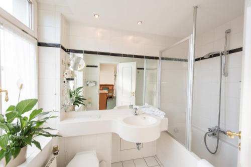 艾森纳赫埃森纳赫凯瑟霍夫酒店的白色的浴室设有水槽和淋浴。