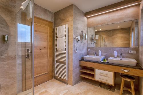 巴特霍夫加施泰因Hotel Zum Stern的一间带两个盥洗盆和淋浴的浴室