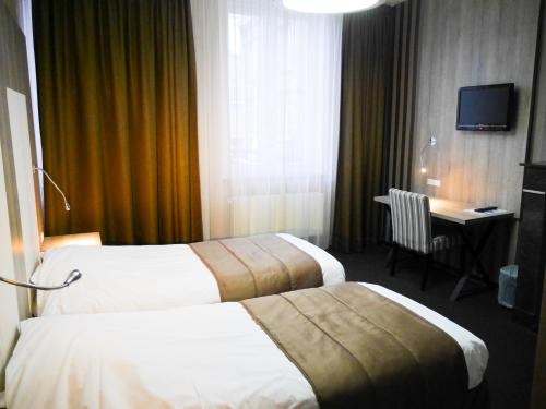 鲁汶米勒克隆酒店的酒店客房配有两张床和一张书桌