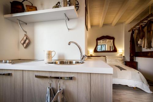 布里维奥Le Casette Apartments - byMyHomeinComo的一个带水槽的厨房和一张位于后面的床